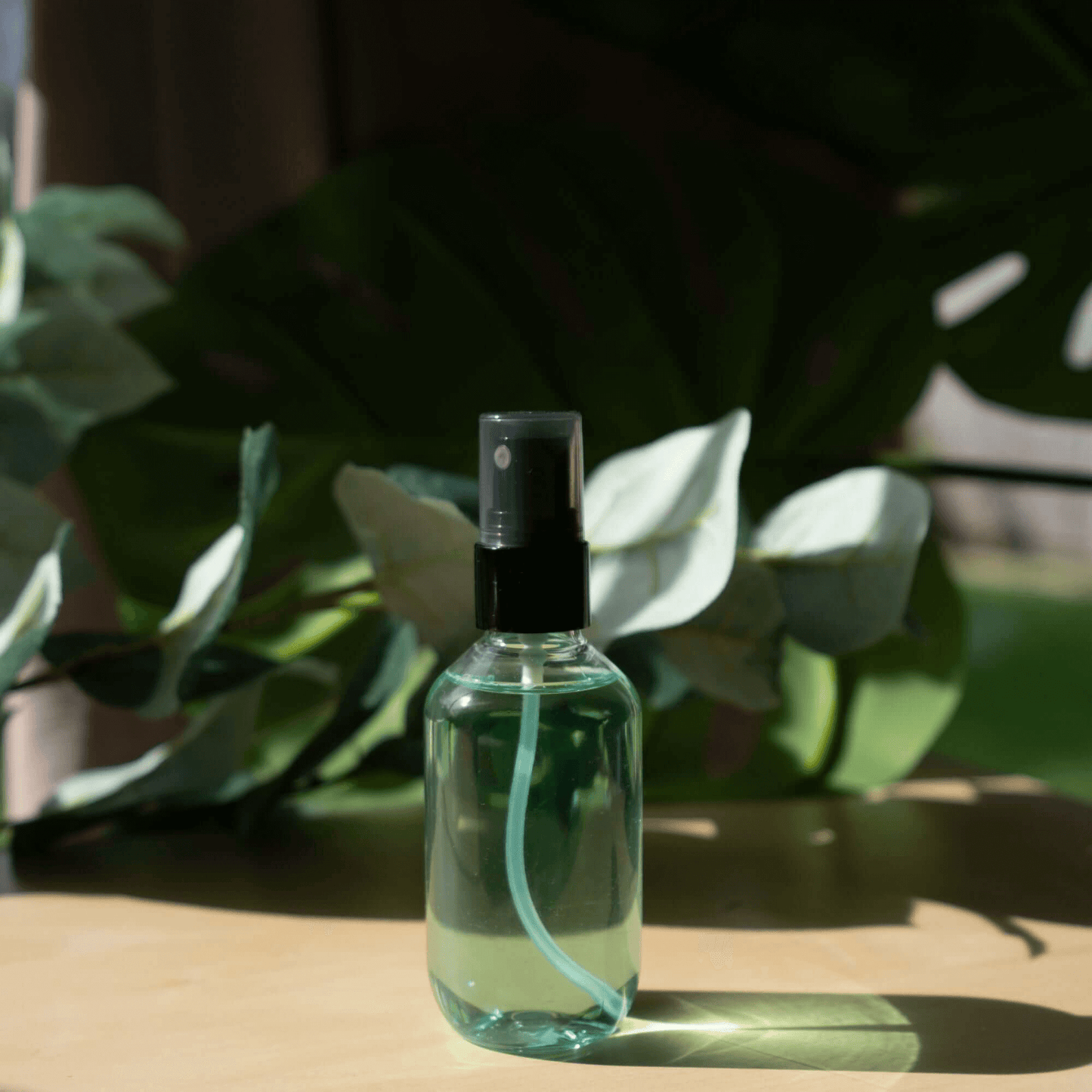 MIANIMED Premium skincare green spray bottle with natural leaves in background.