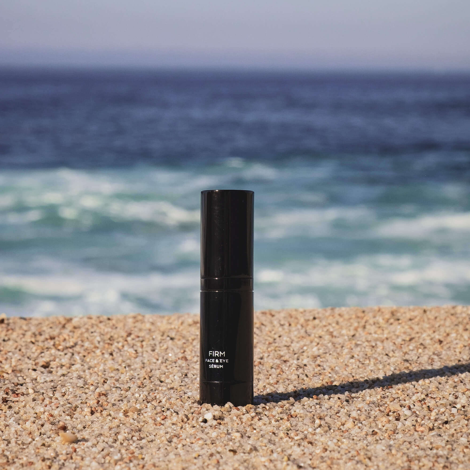 MIANIMED Premium skincare product on a sandy beach with ocean waves in the background