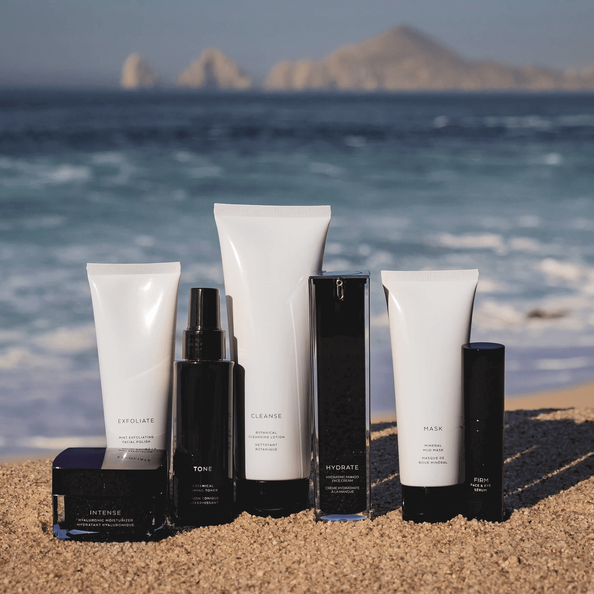 MIANIMED premium skincare products displayed on sandy beach with ocean and mountains in the background