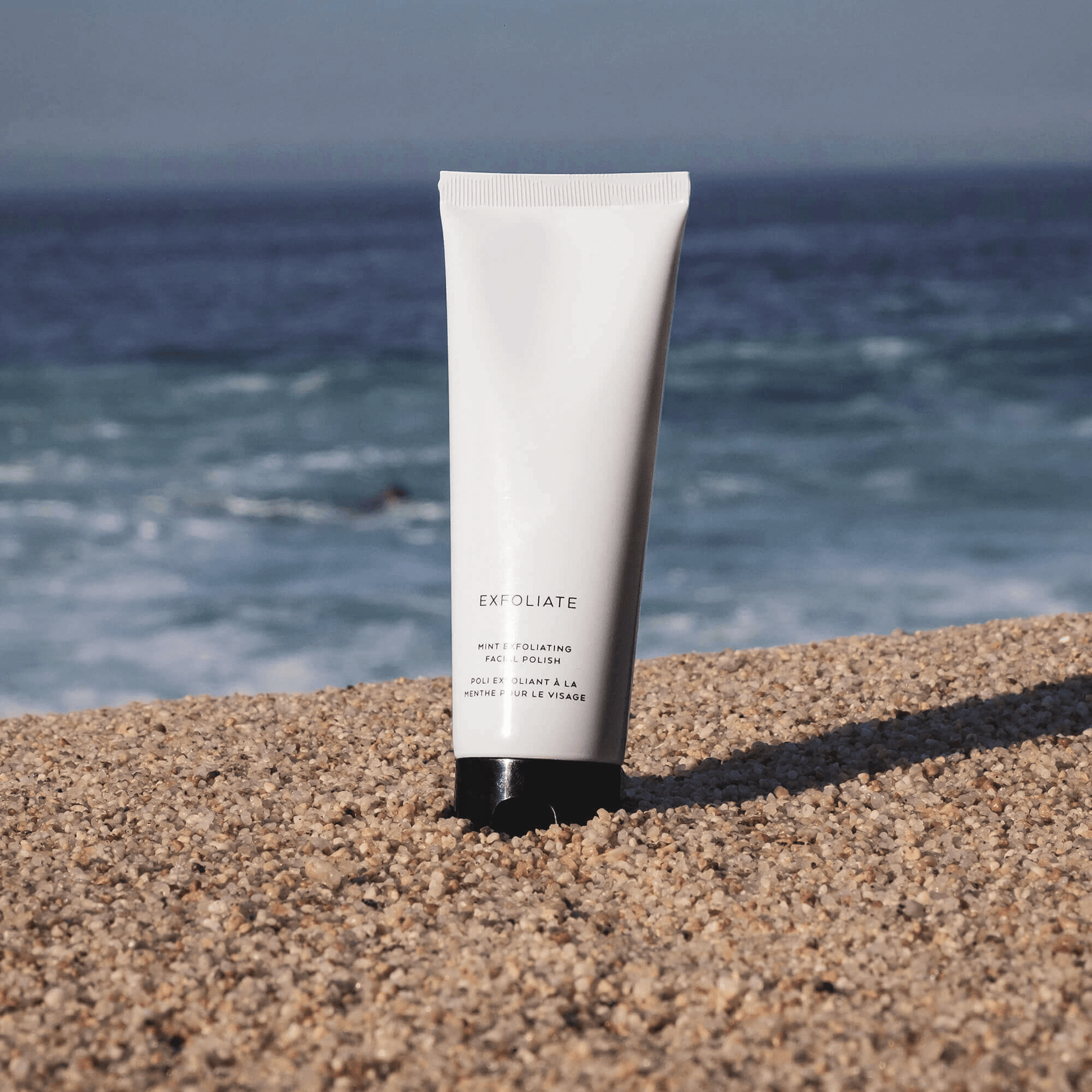 MIANIMED Premium skincare exfoliating product displayed on sandy beach with ocean background